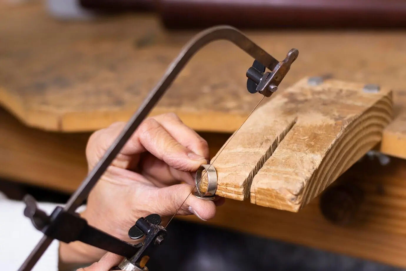 A jeweler’s hands at work on a ring.
